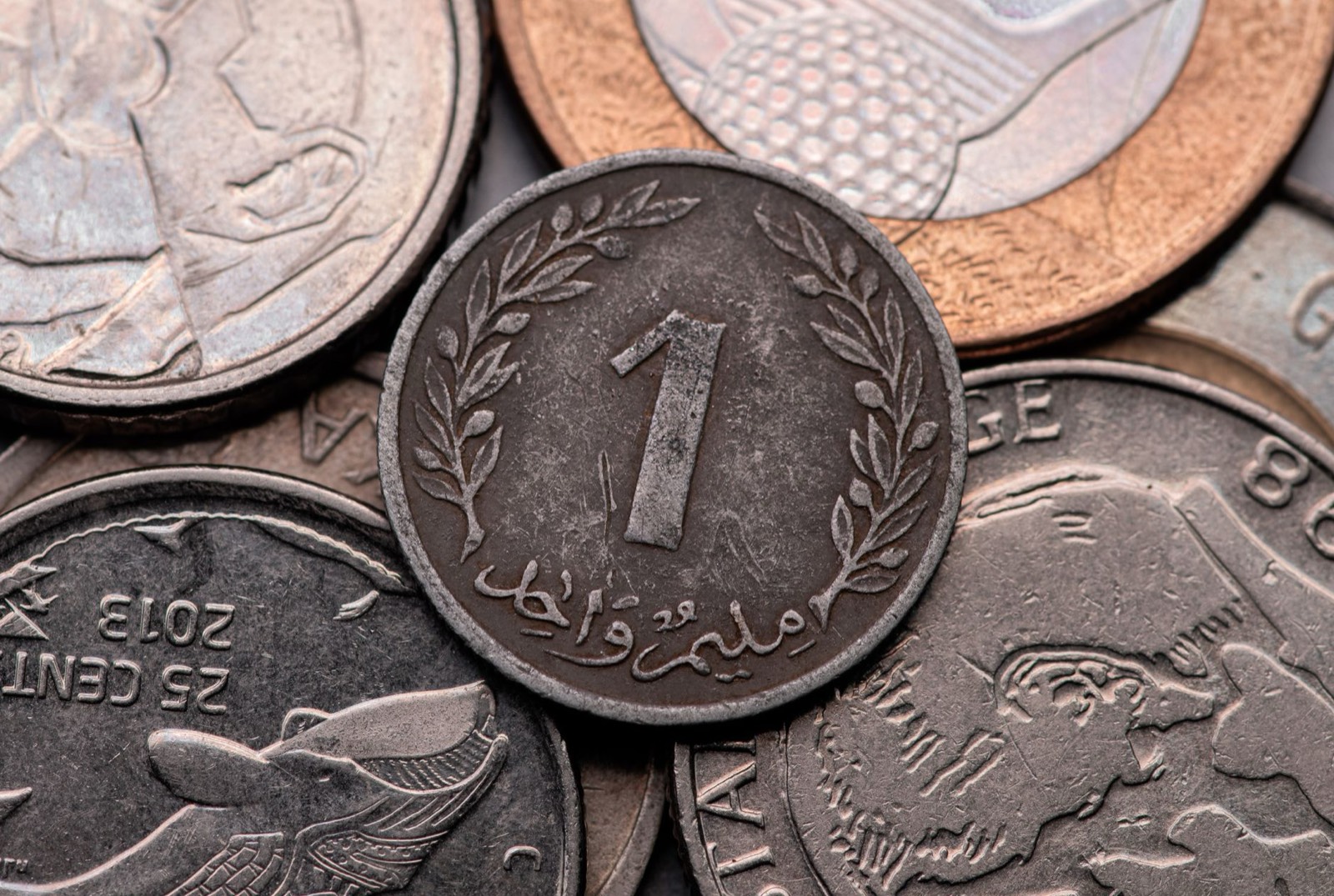 Reçu de station-service et pièces en dinars tunisiens posés sur un tableau de bord