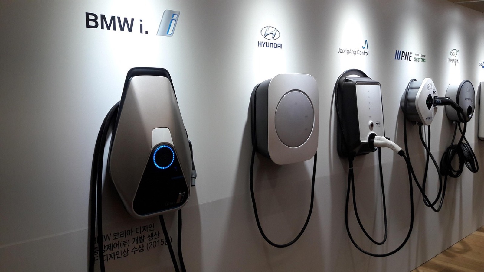 Wallbox murale fixée dans un garage, câble branché sur une voiture électrique