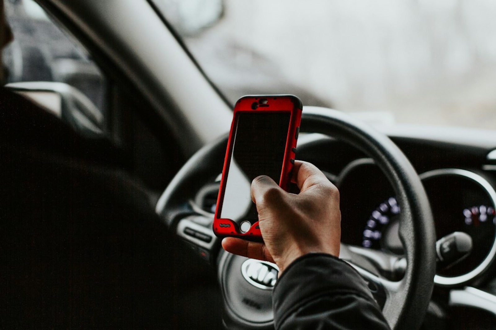 Chauffeur VTC consultant une application de calcul de tarif sur smartphone